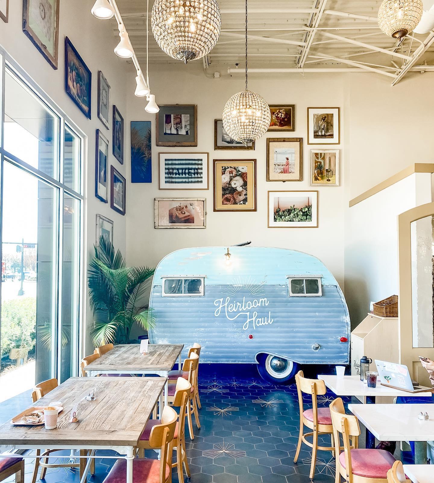 Dining area of a restaurant that features a small camper and photo wall