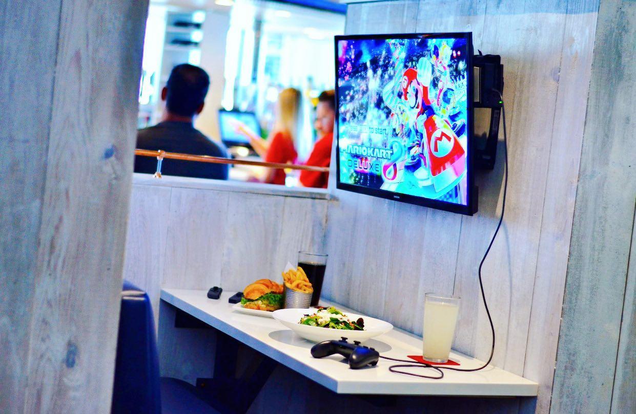 a restaurant seating area with a tv to play video games