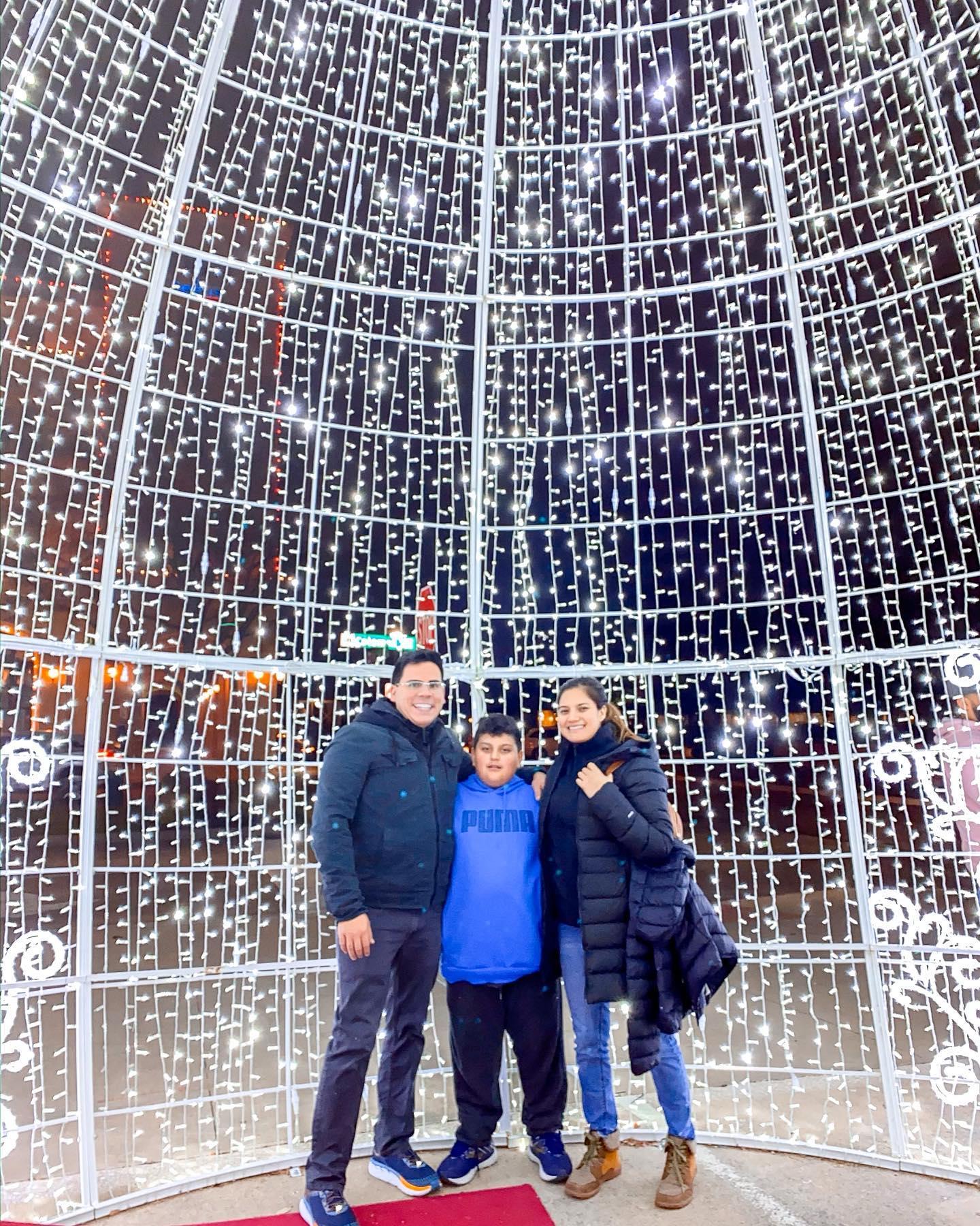 a family posing in a big dome strung with lights