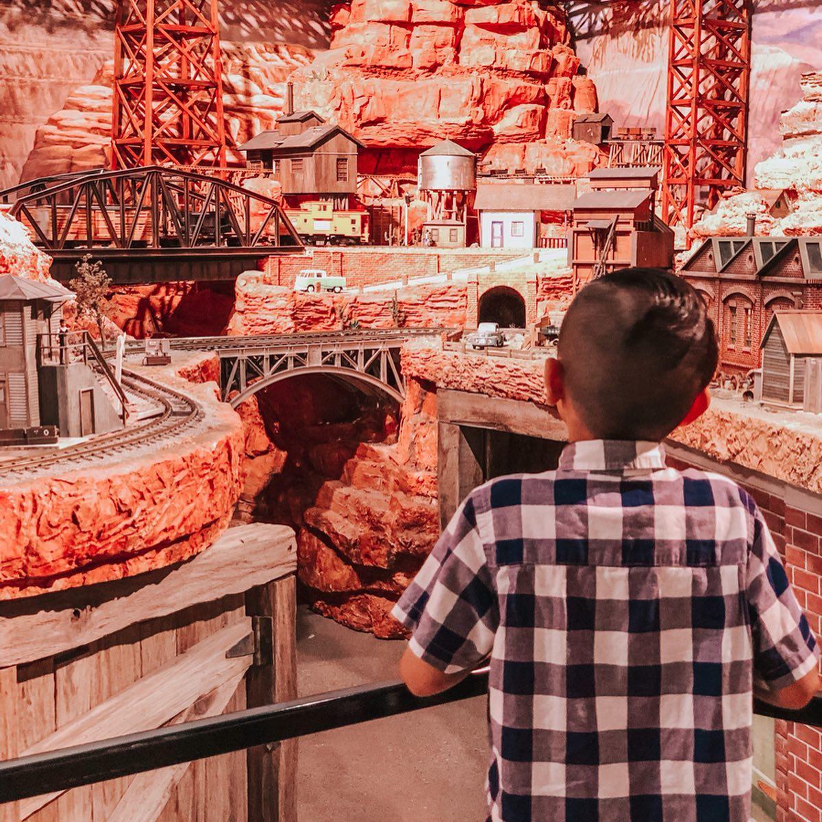 a little boy looking at a display in a train museum