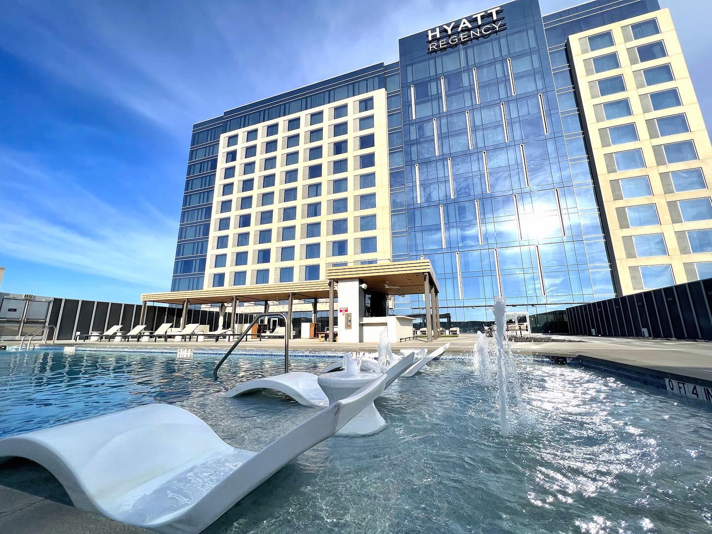 The pool at Stonebriar, the large glass-faced building in the background shines in the sun.