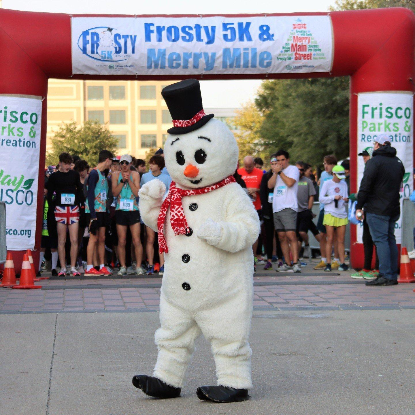 A snowman mascot poses in front of marathon runners waiting to start a race.