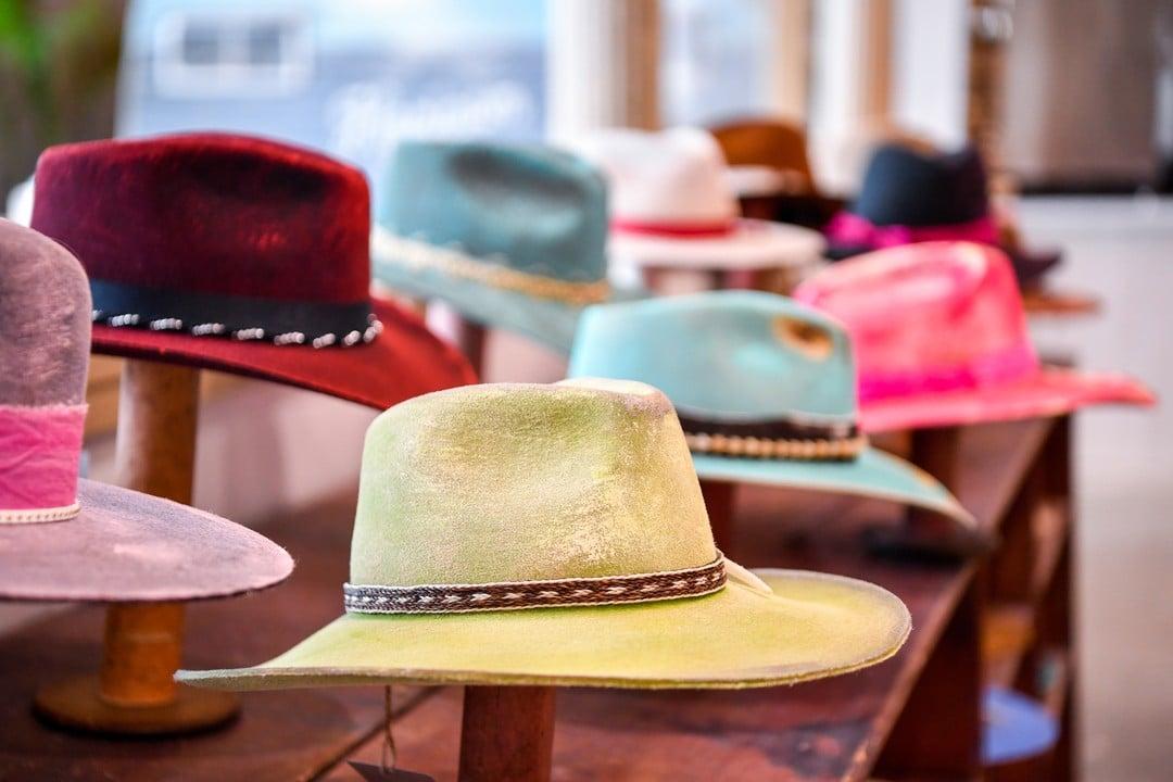 An assortment of cowboy hats in colors red, pink, blue and white on display at a boutique in Frisco.