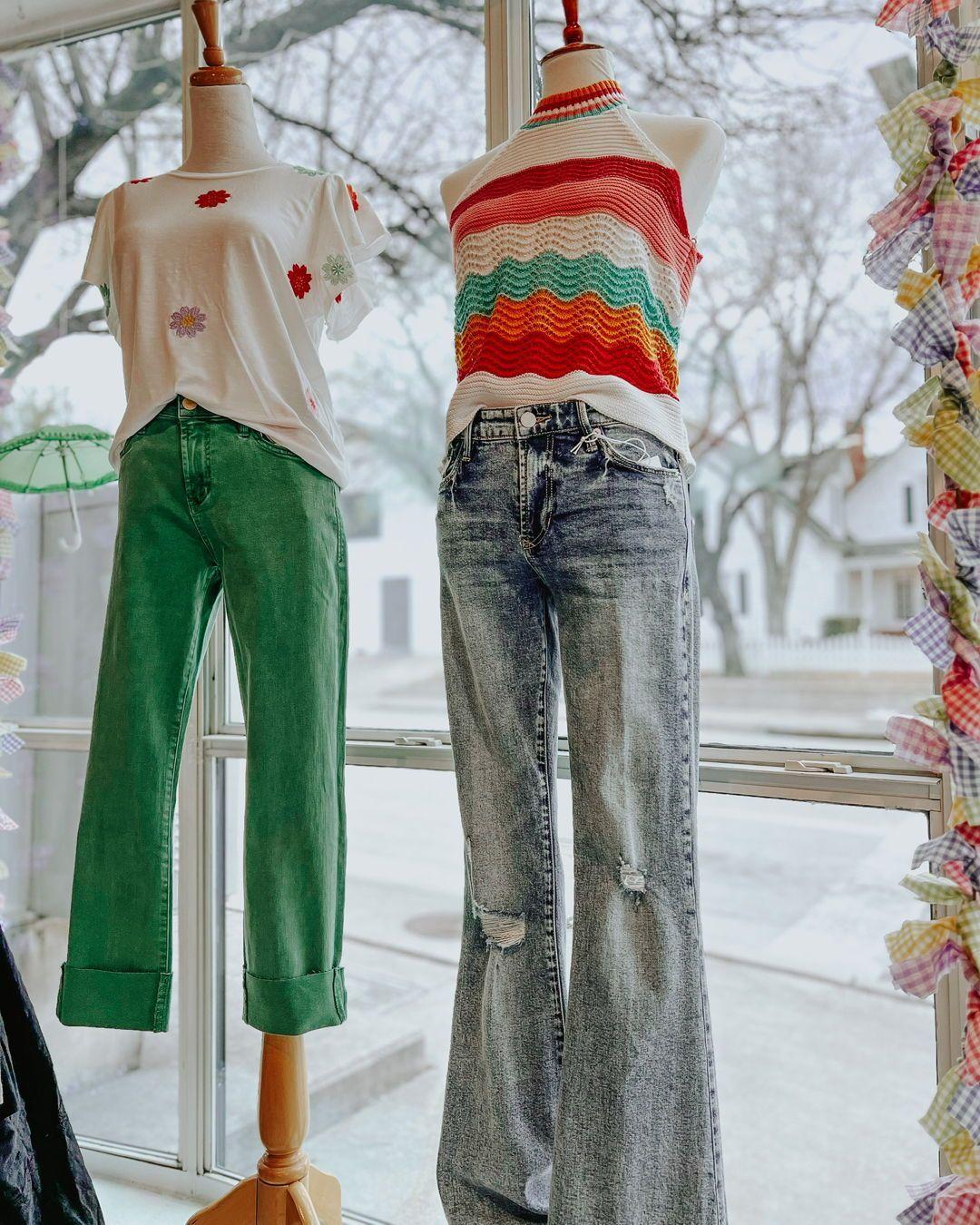 mannequins in a window wearing stylish outfits