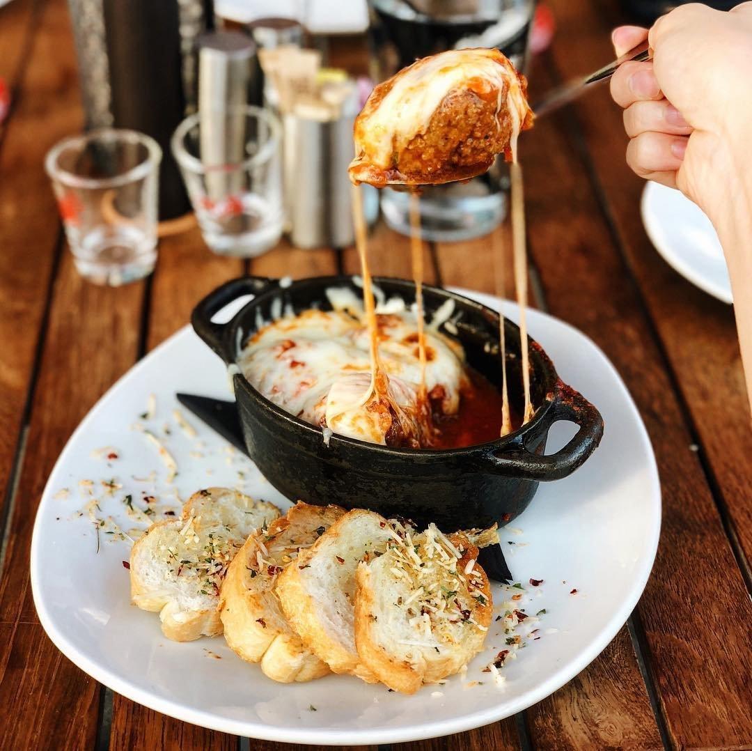 a person lifting a spoonful of food out of a dish