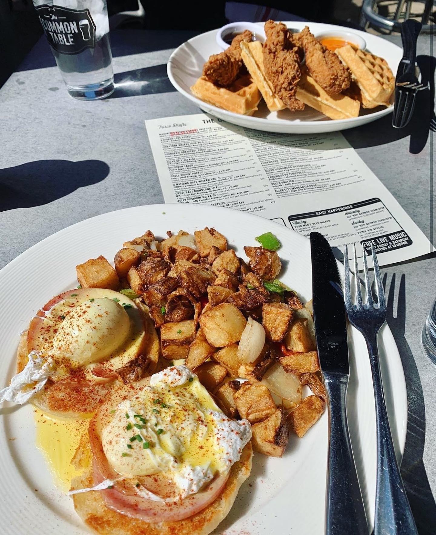 a plate of eggs benedict and hashbrowns in front of a plate of chicken and waffles