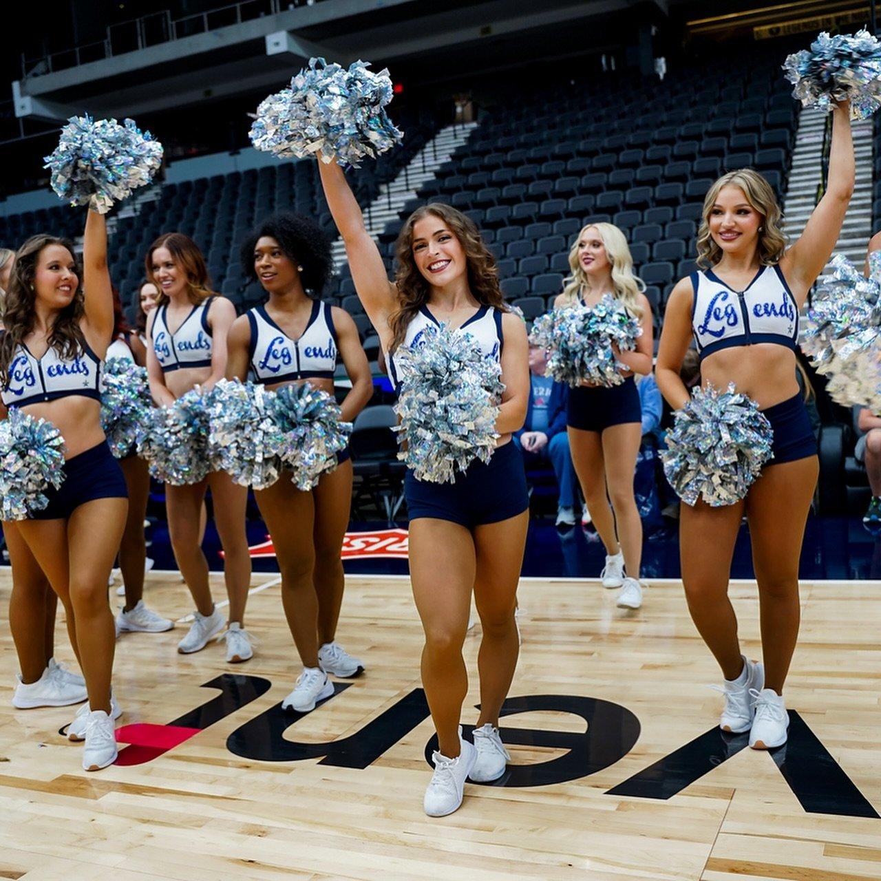 Cheerleaders doing a cheer with their pompoms in the air