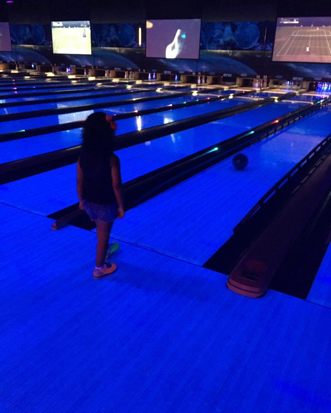 a child bowling at a glow in the dark bowling alley