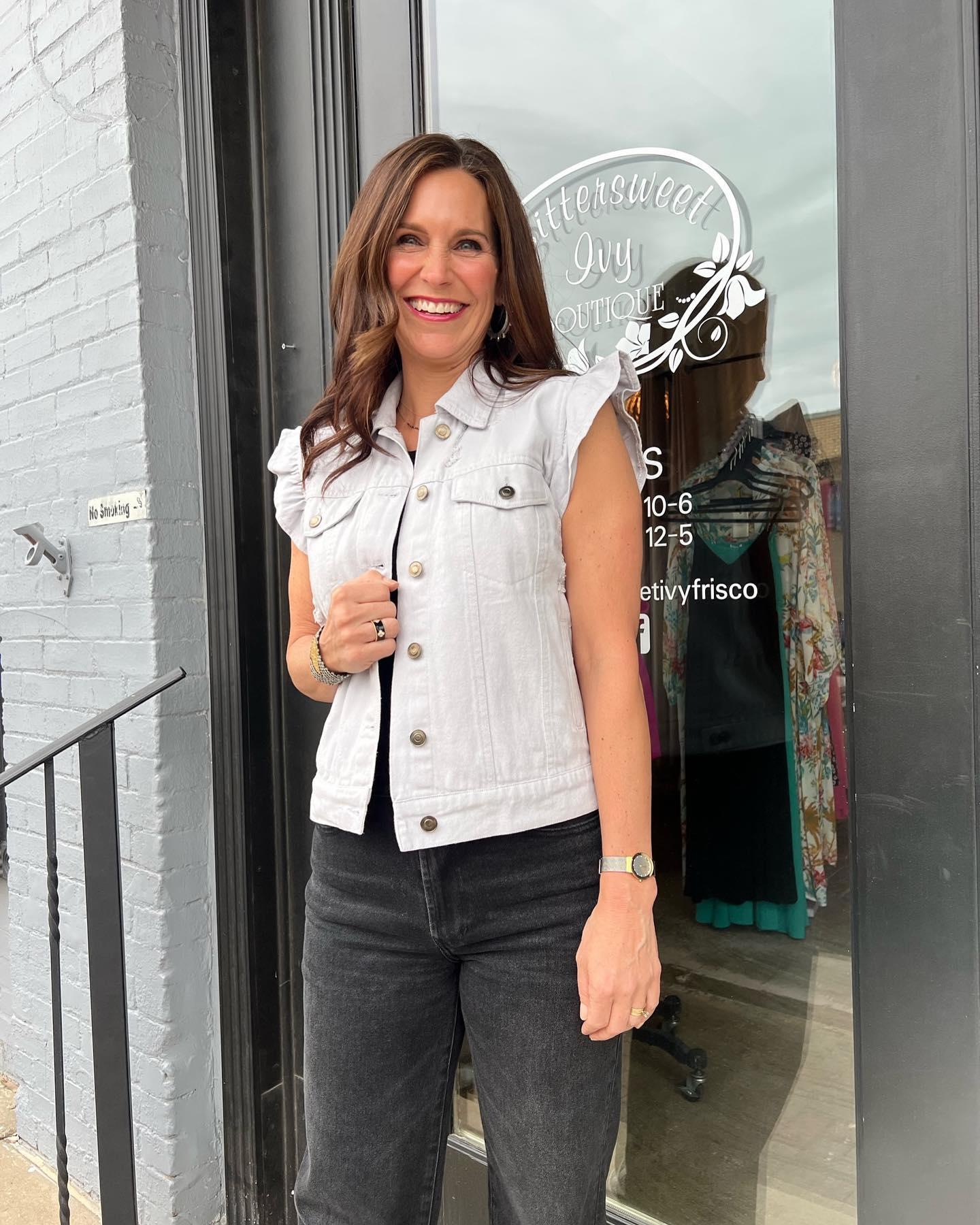 a woman smiling in front of a store front