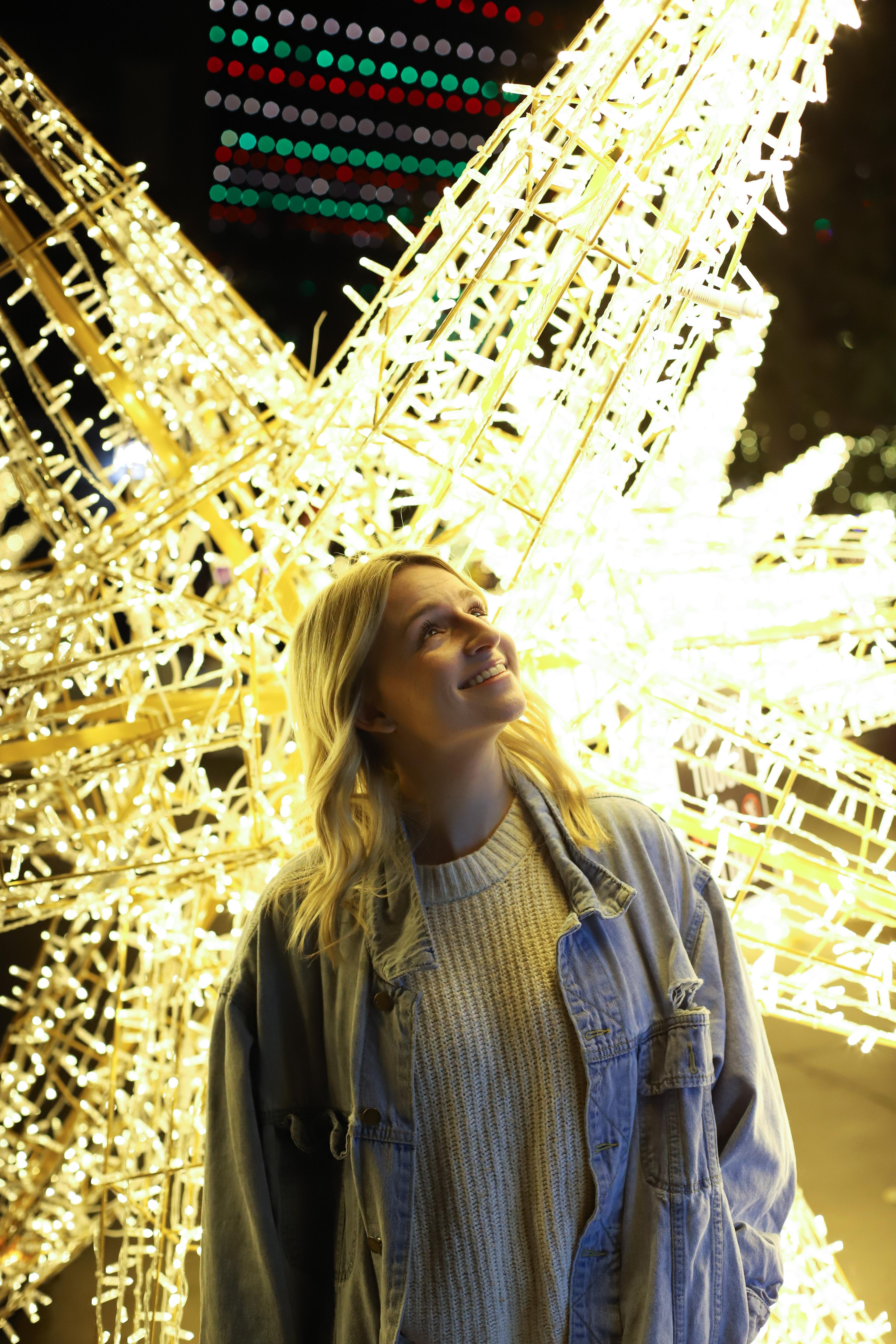 a woman looking at christmas lights