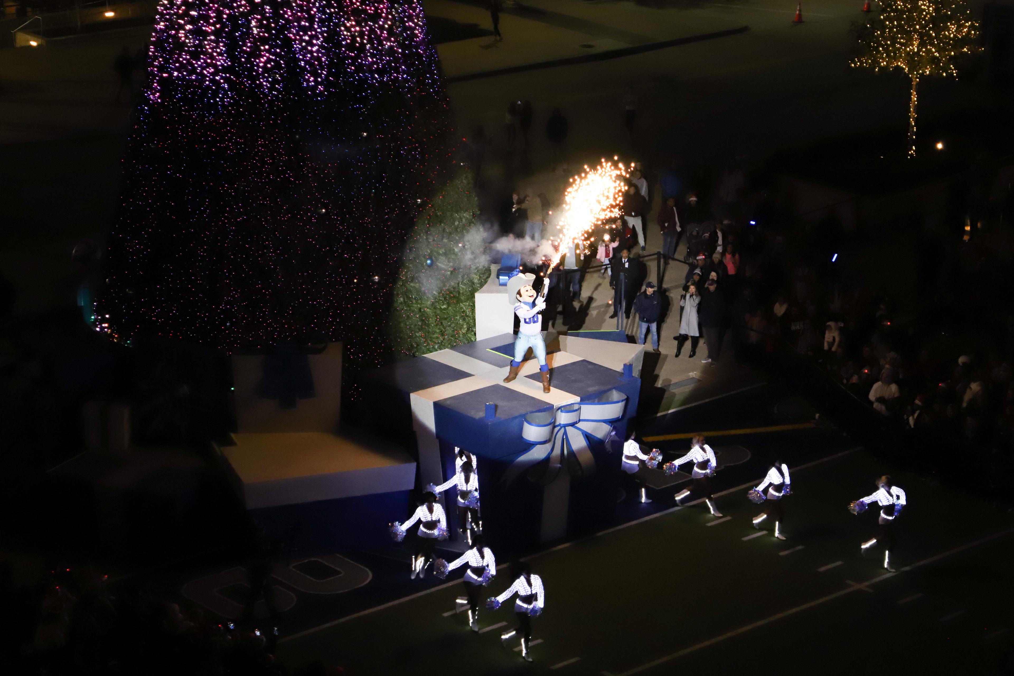 the Dallas Cowboys mascot holding a large sparkler