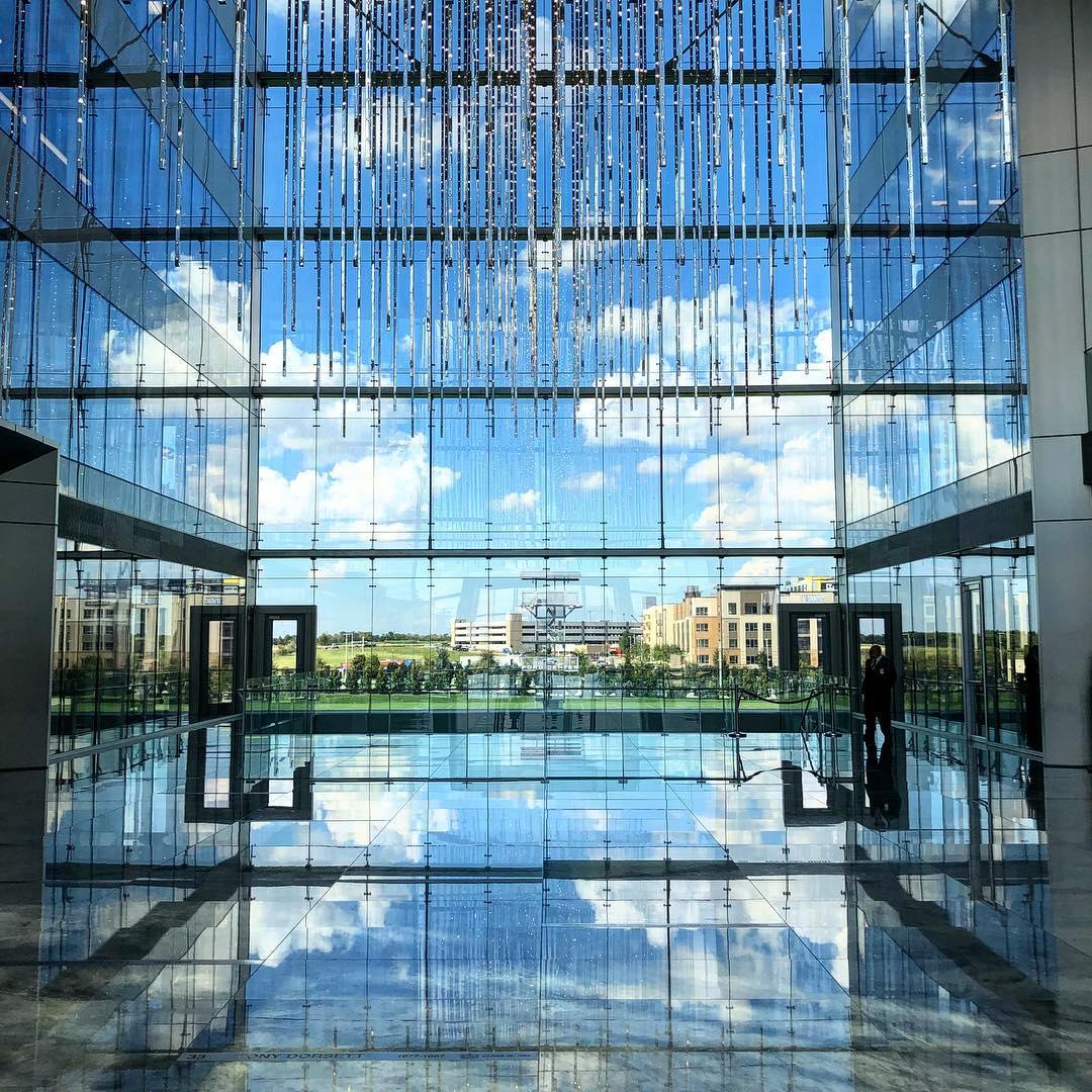 a building made of glass with a hanging mirror chandelier
