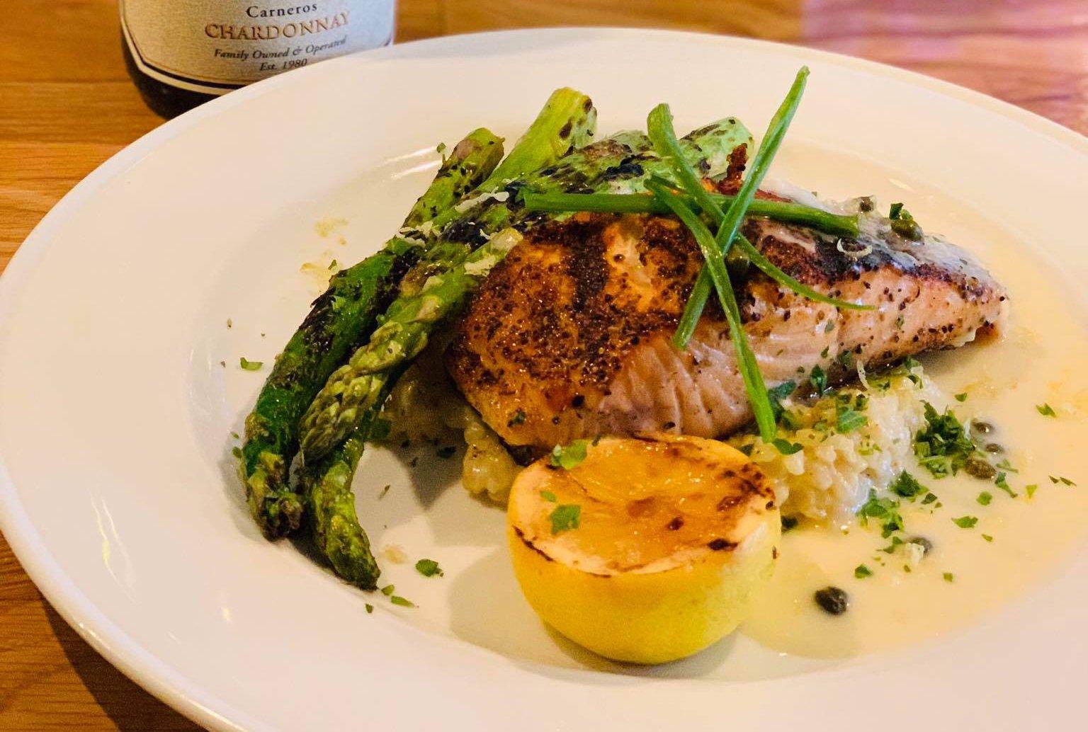 a plate of fish with a side of asparagus