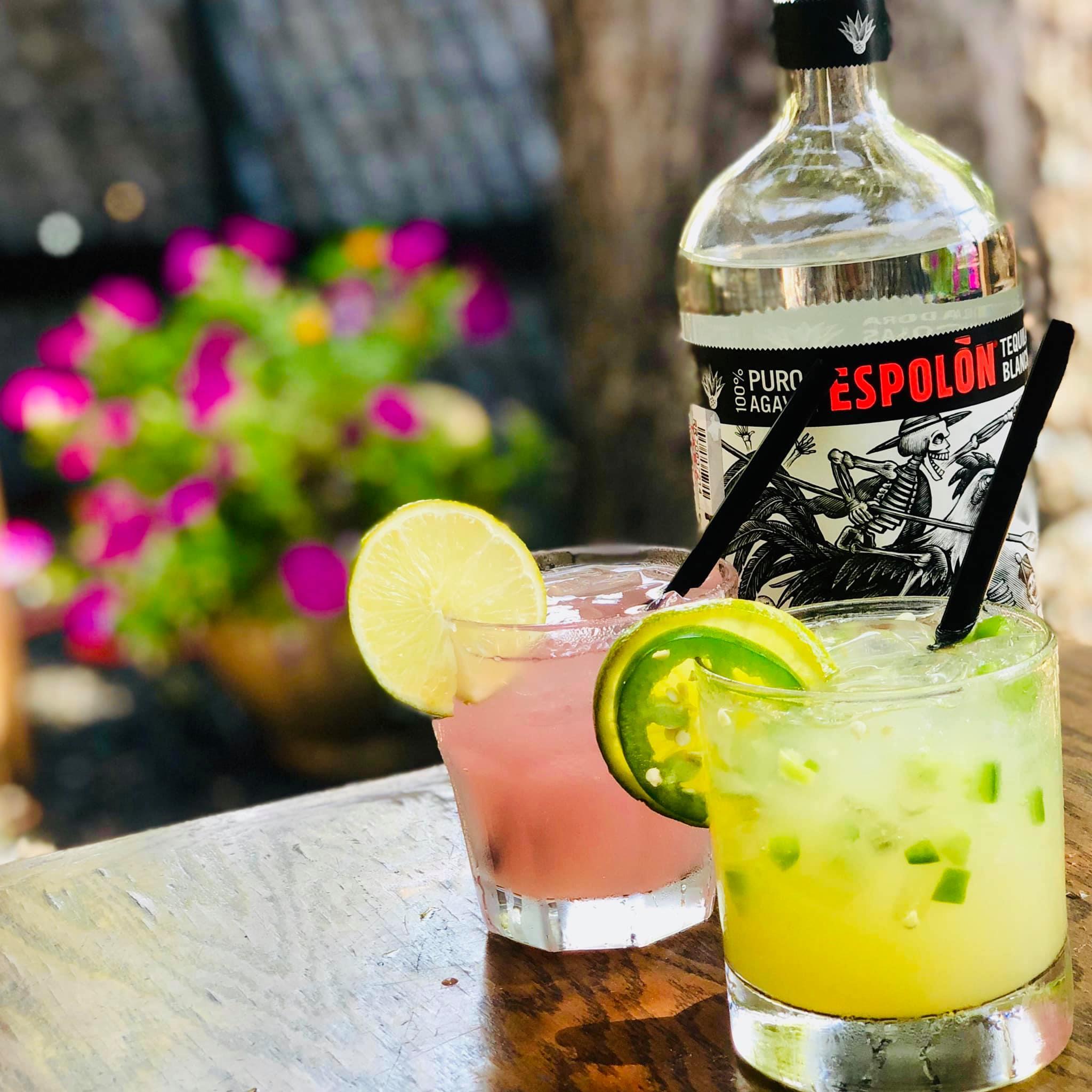 two colorful cocktails with garnish on the rim