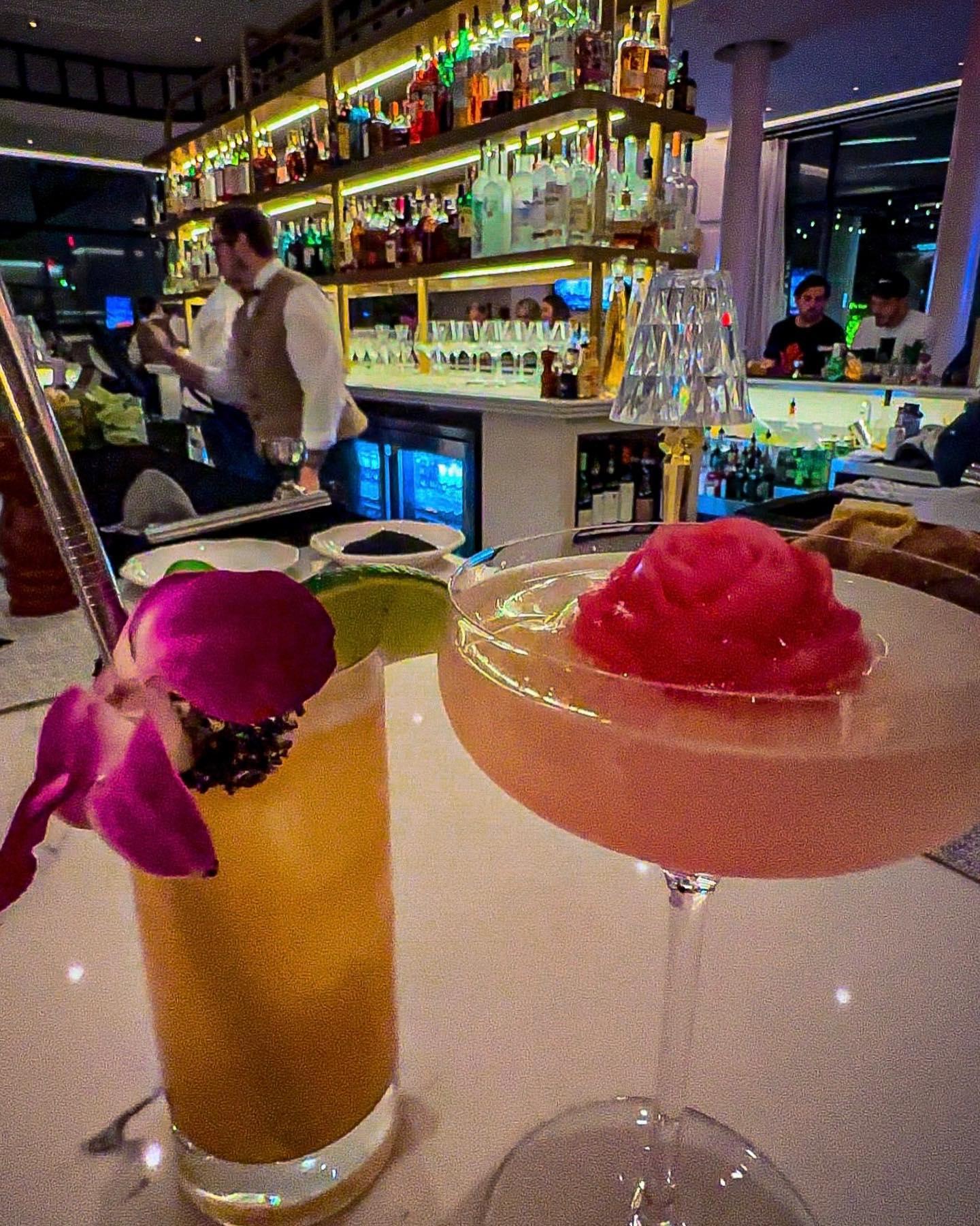 two cocktails garnished with flowers