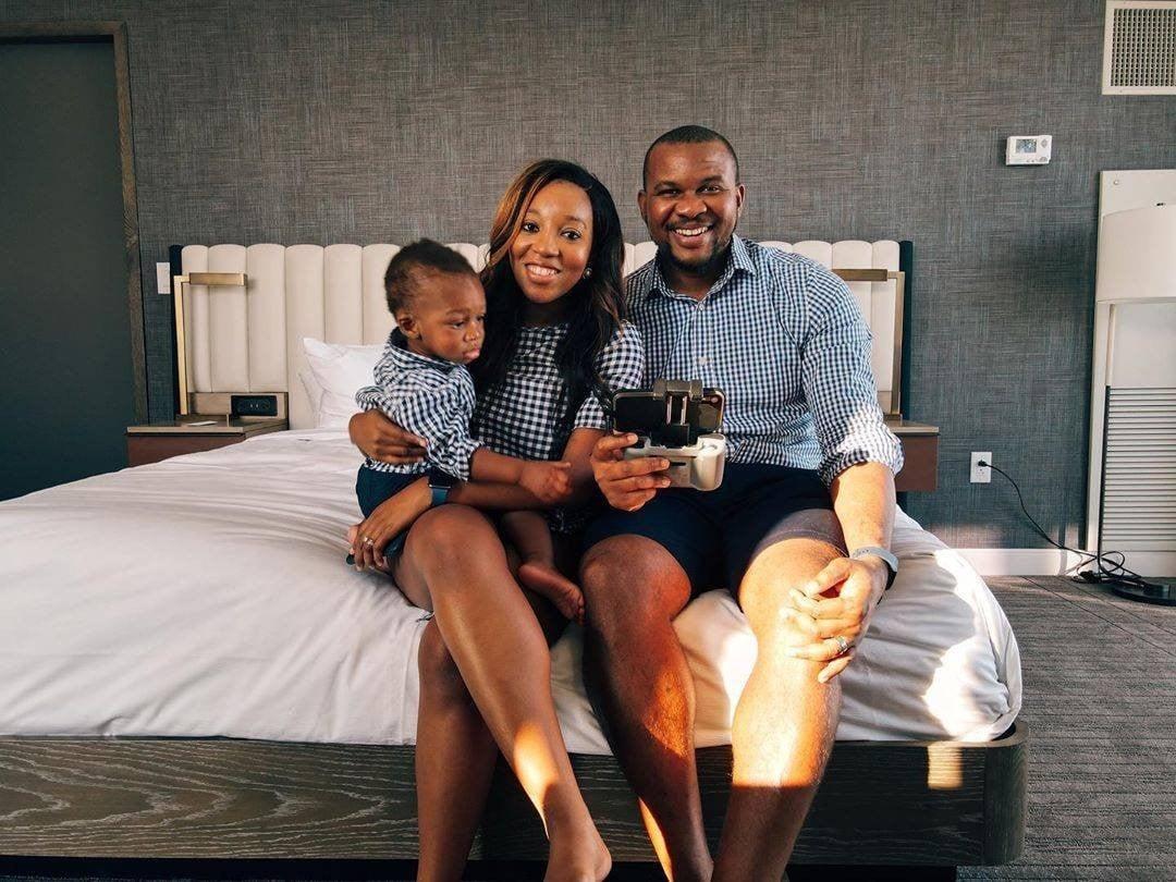 A family wearing matching clothes sitting on a bed
