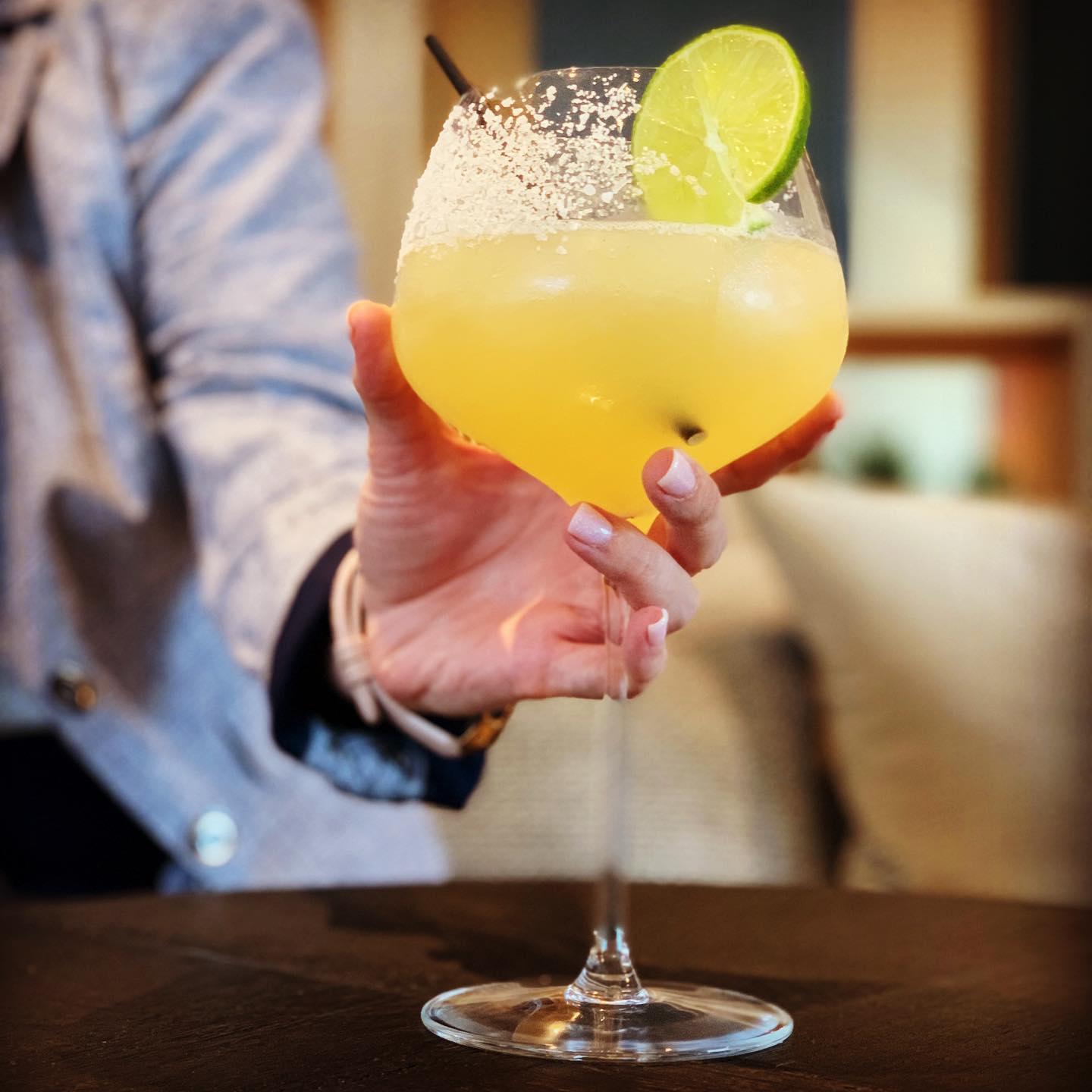 a woman holding a large cocktail