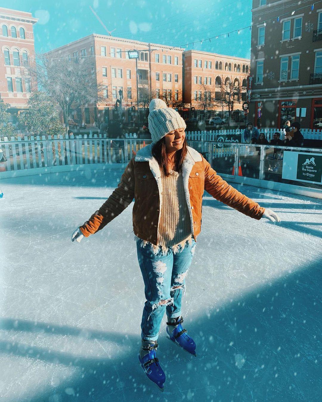 A woman enjoying the snow falling around her while skating