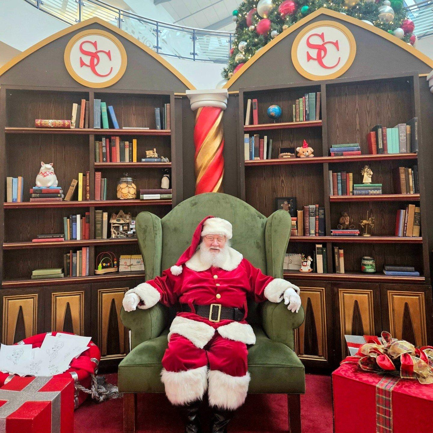 Santa sitting in his library on a large chair