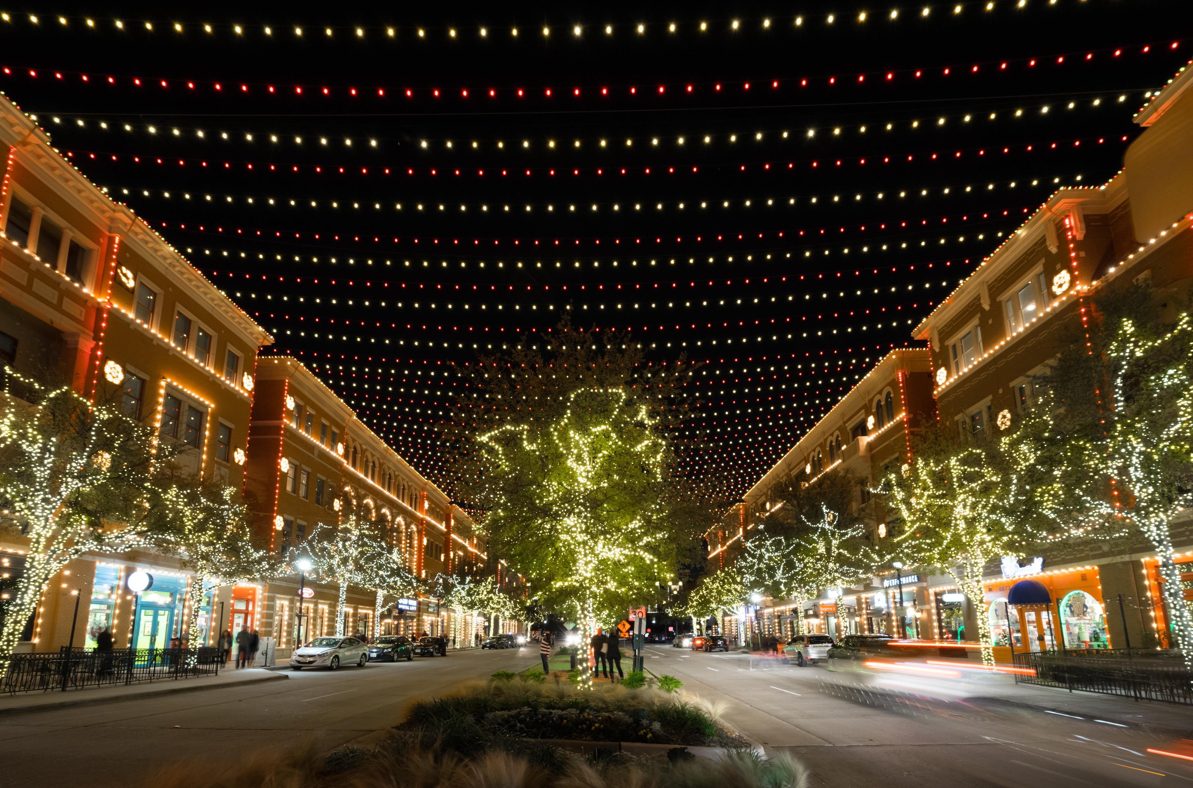 a road lined with shops and hanging lights over the square
