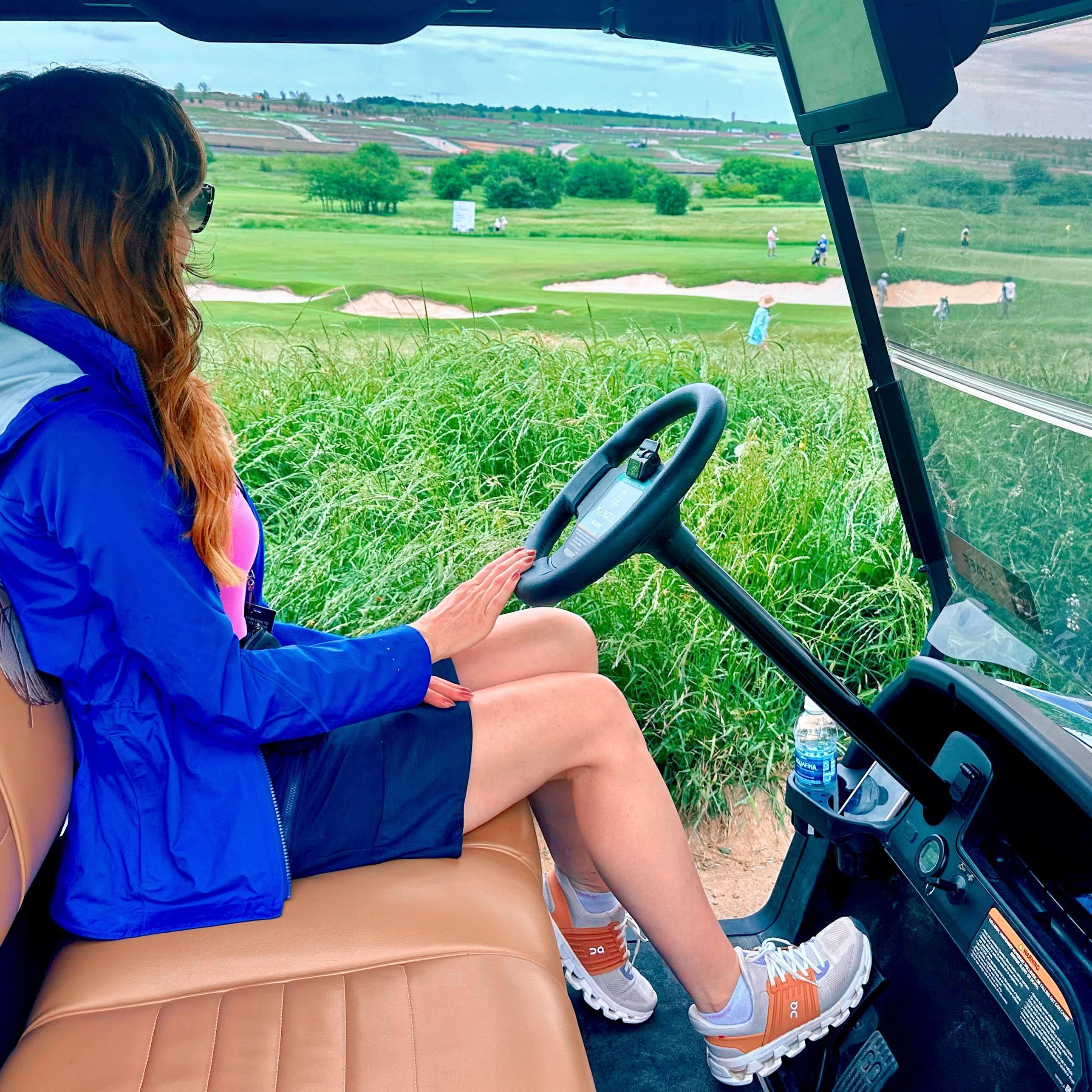 a woman driving a golf cart