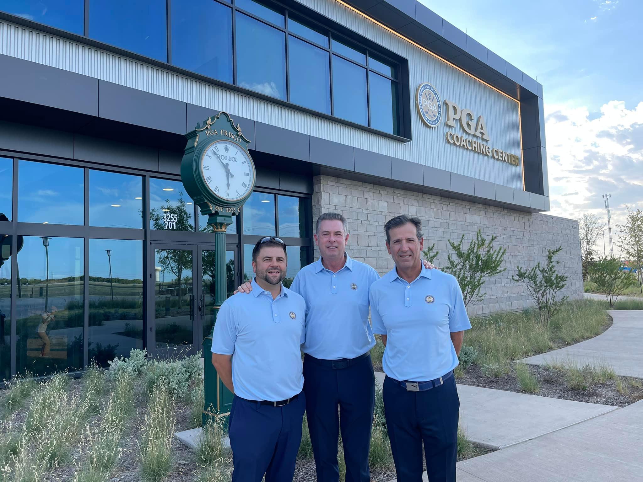 Three men standing at the entrance of the PGA Coaching Center