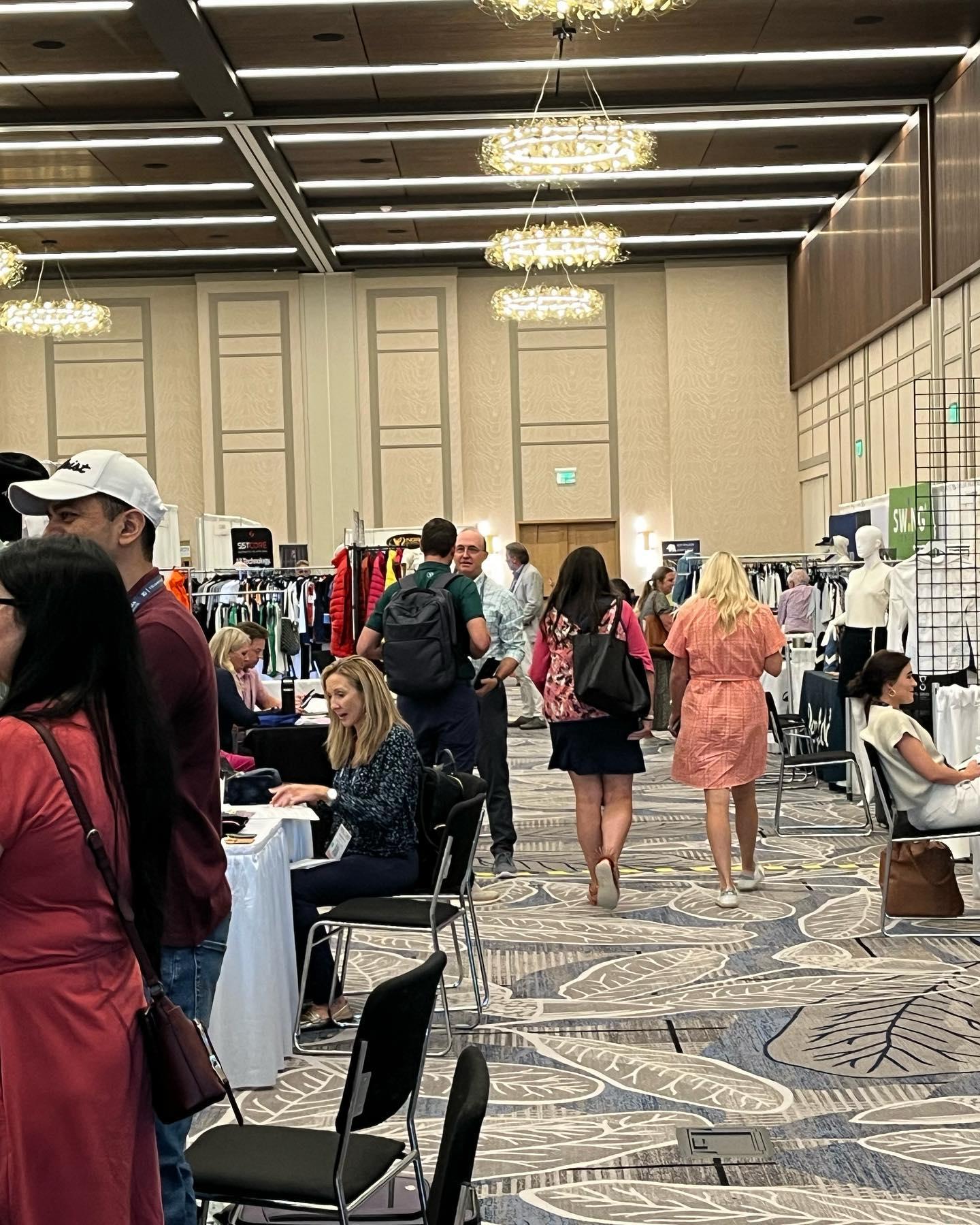 A conference centre full of people and different booths