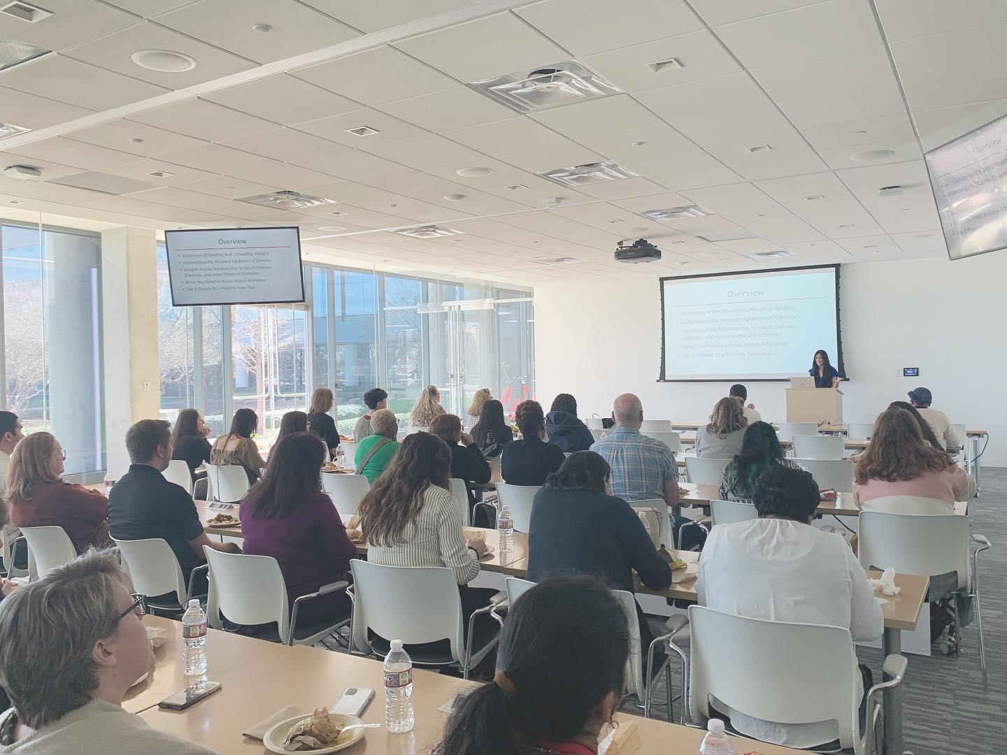 A room full of people at tables for a conference