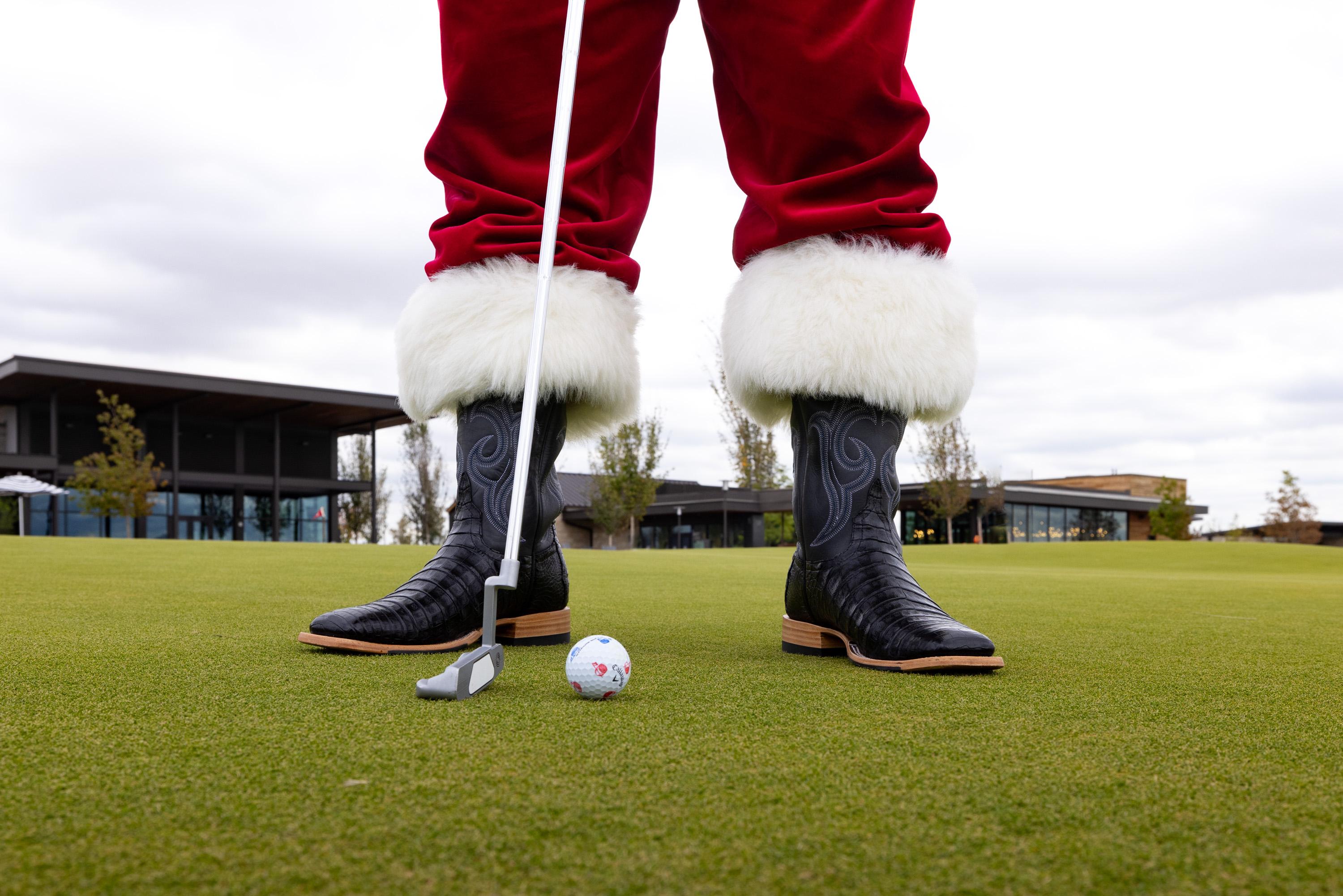Santa wearing cowboy boots putting