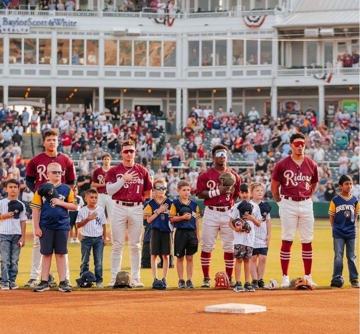 A team with children standing for the national anthem