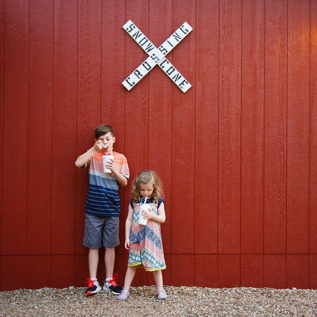 Kids eating slushies against a red wall