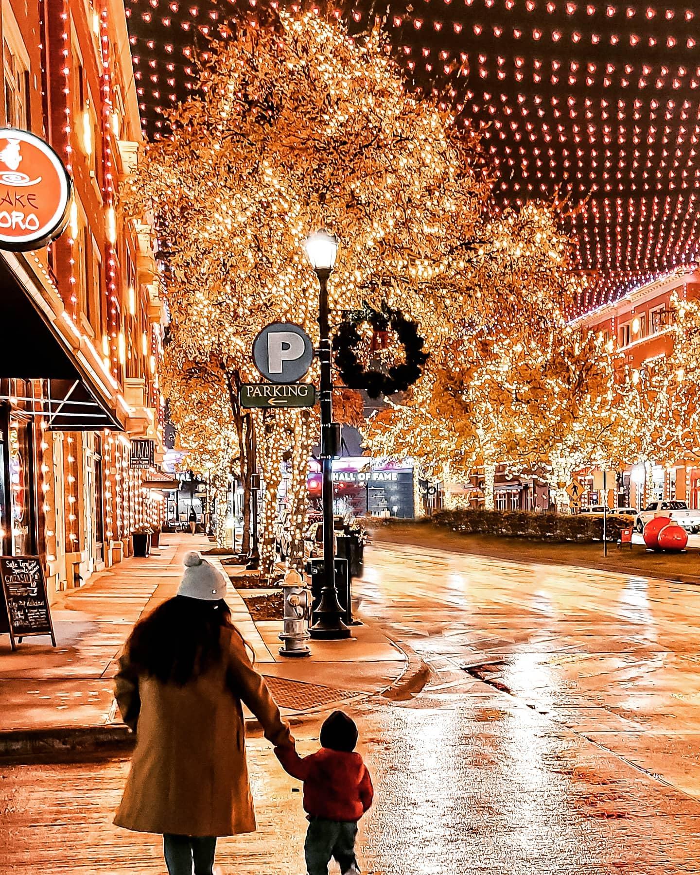 a mother and child walking through the square at Christmas time