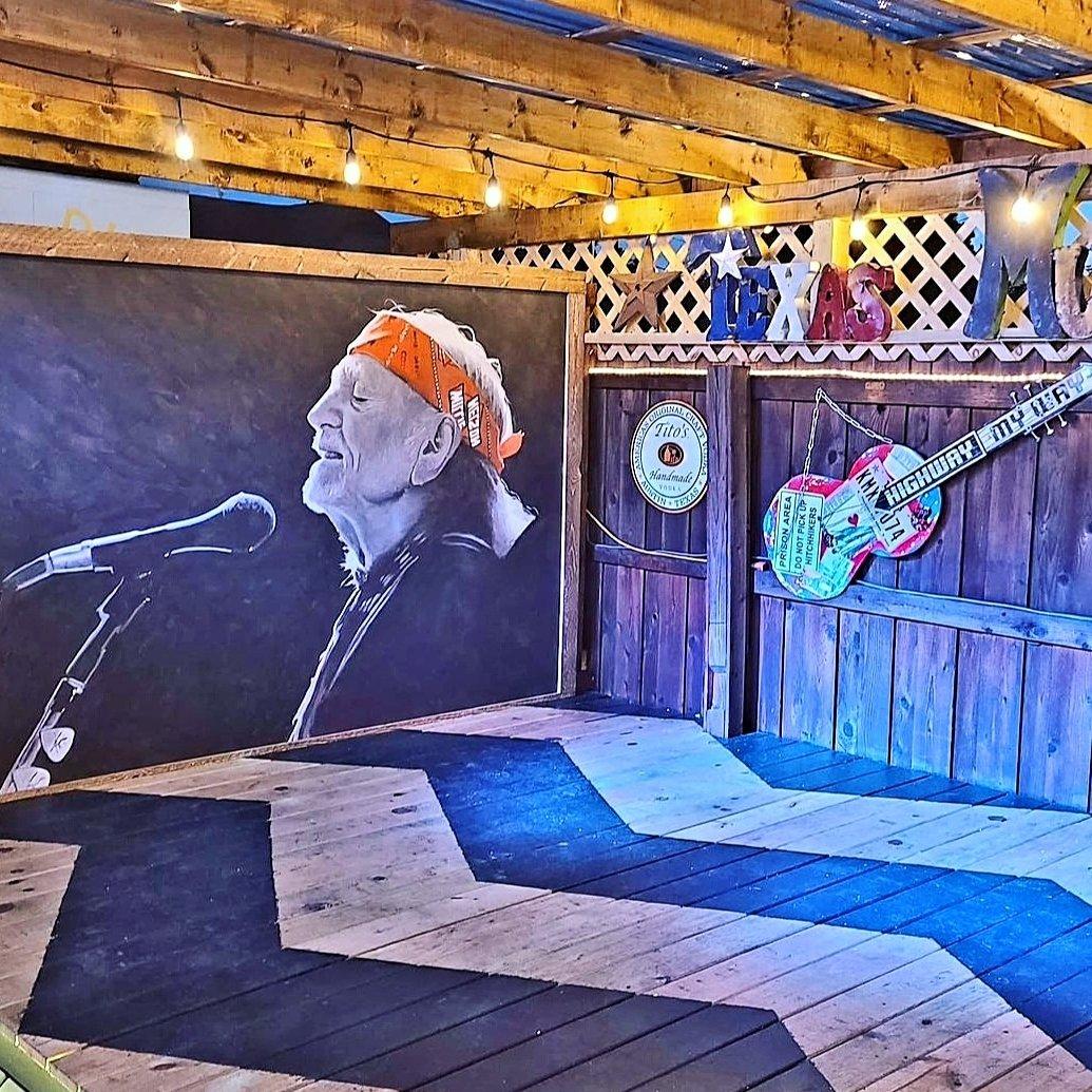 a mural of Willie Nelson painted on the wall of a stage