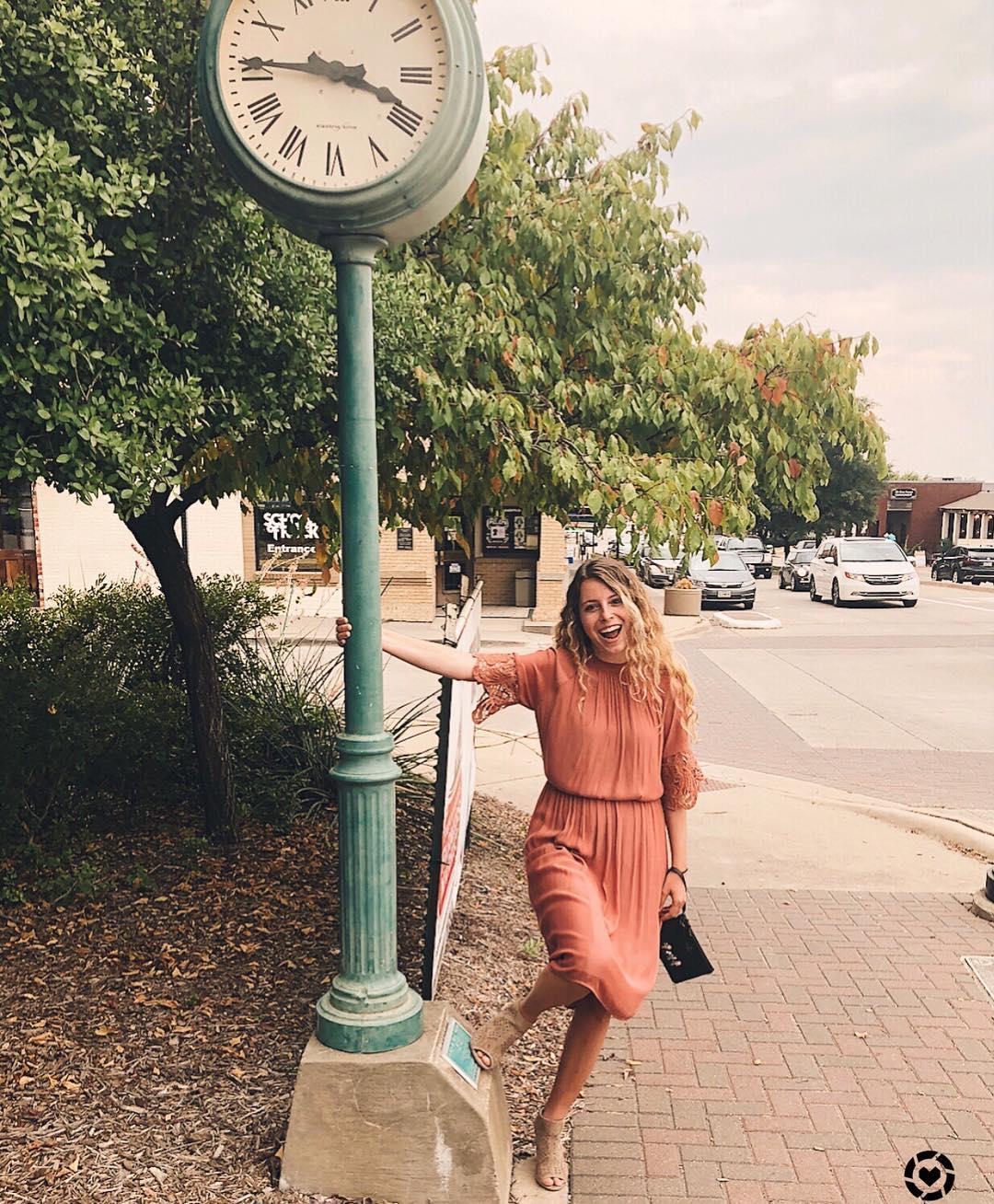 a woman holding a pole that has a clock on top