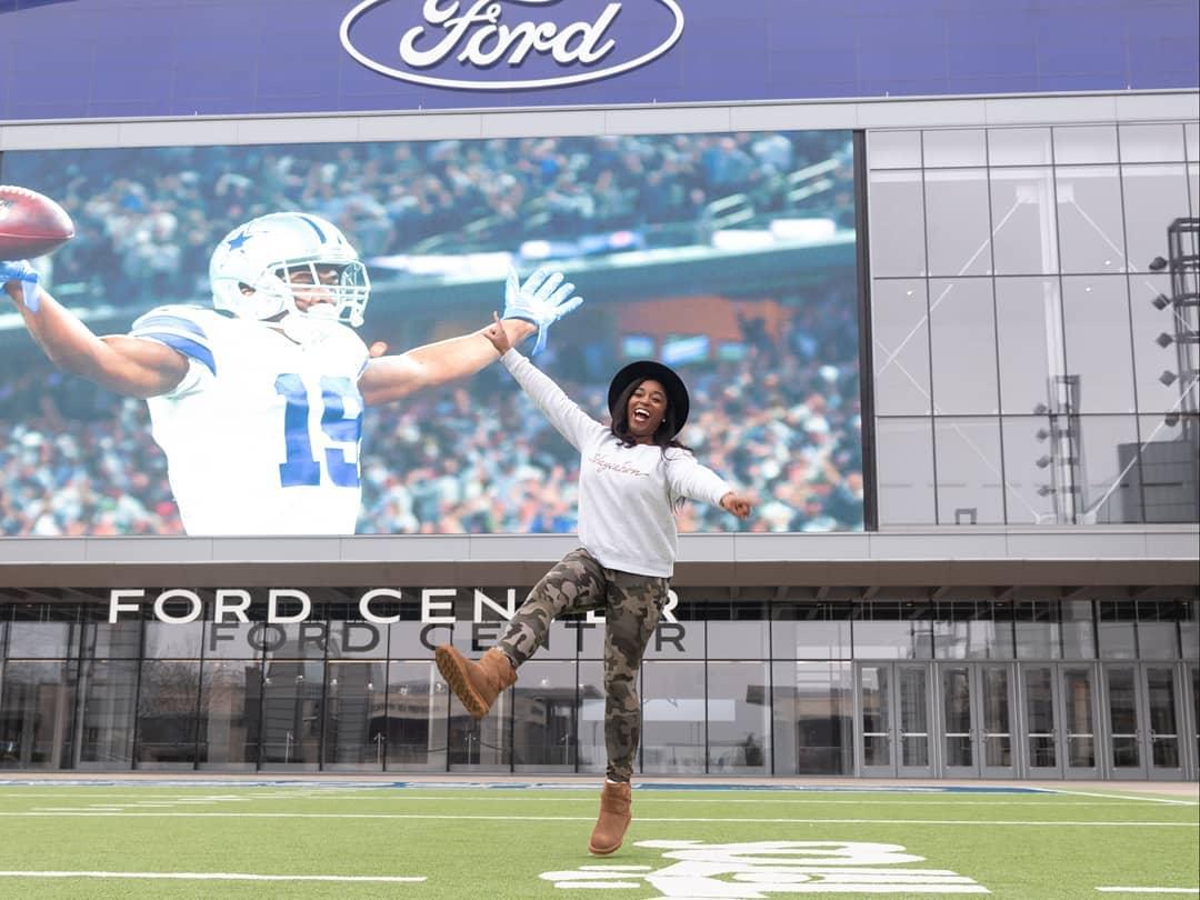 a woman jumping in front of the Ford Center